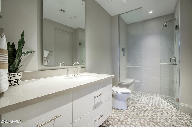 bathroom with toilet, visible vents, a tile shower, and vanity