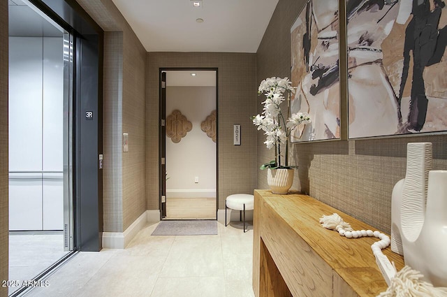 bathroom with baseboards, tile patterned flooring, and elevator