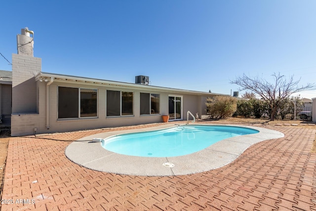 view of swimming pool featuring central air condition unit and a patio area