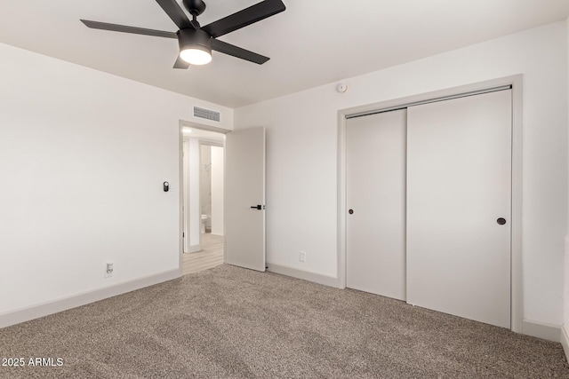 unfurnished bedroom featuring ceiling fan, a closet, and carpet