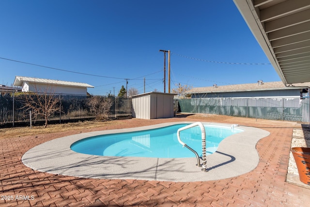 view of swimming pool featuring a patio and a shed