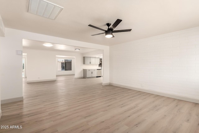 unfurnished living room with ceiling fan, brick wall, and light wood-type flooring