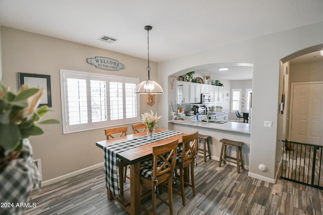 dining area with dark hardwood / wood-style flooring, sink, and a wealth of natural light