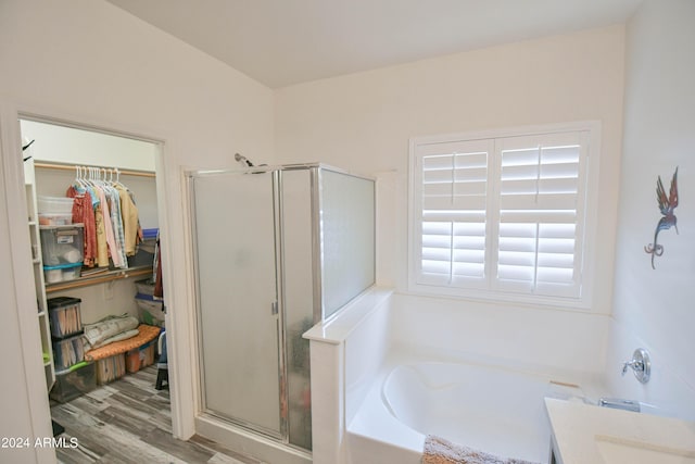 bathroom featuring wood-type flooring, separate shower and tub, and vanity