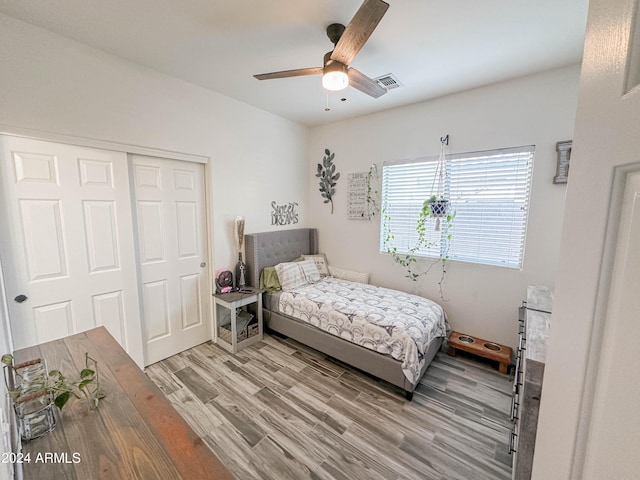 bedroom with light hardwood / wood-style floors, a closet, and ceiling fan