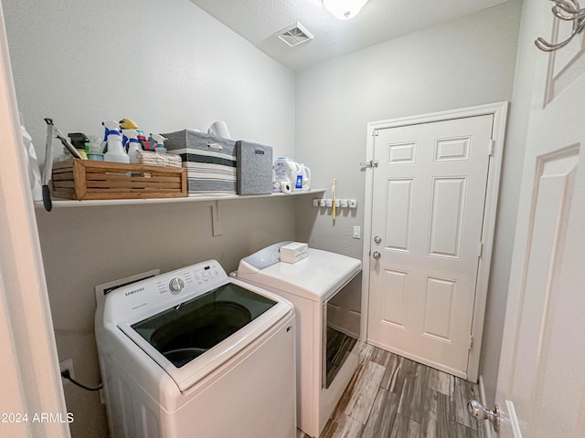 laundry room with hardwood / wood-style floors and washer and clothes dryer