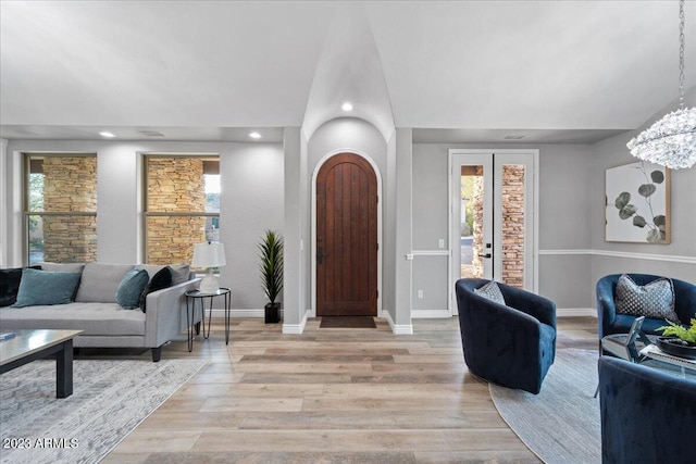 foyer entrance featuring a chandelier, light hardwood / wood-style floors, and french doors