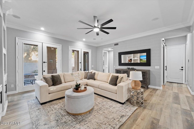 living room with light hardwood / wood-style floors, ceiling fan, french doors, and crown molding