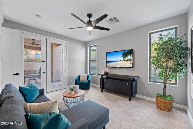 living room featuring light colored carpet, ceiling fan, and french doors