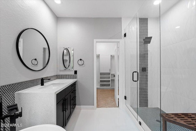 bathroom with tile flooring, a shower with door, and vanity with extensive cabinet space