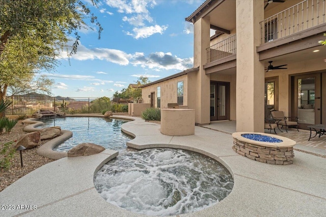 view of pool with ceiling fan, an outdoor fire pit, and a patio area