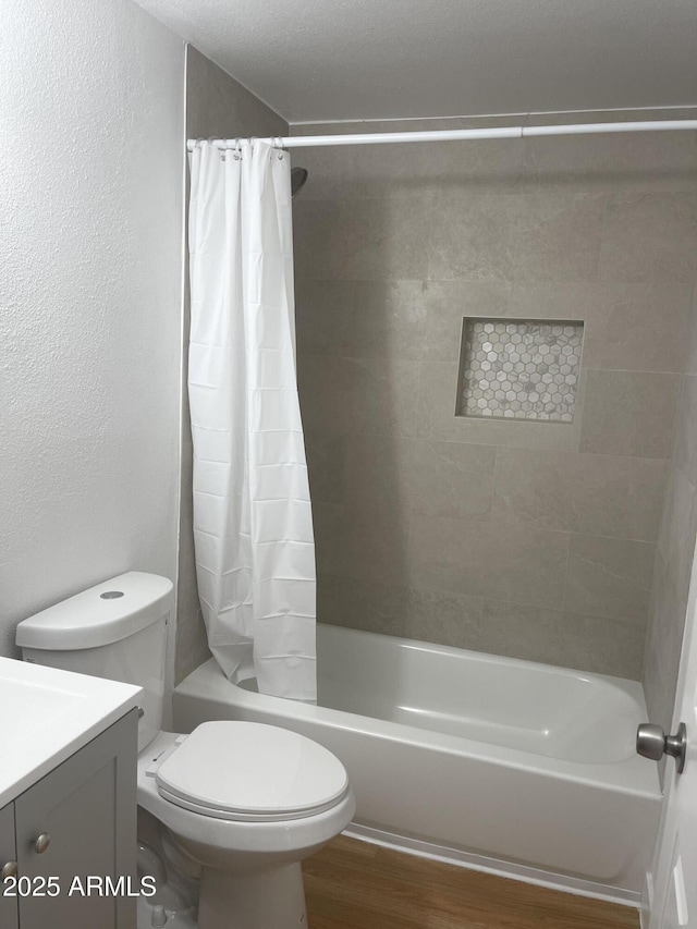 full bathroom featuring shower / bath combo, vanity, hardwood / wood-style flooring, and toilet