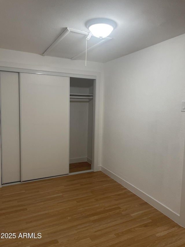 unfurnished bedroom with a closet and wood-type flooring