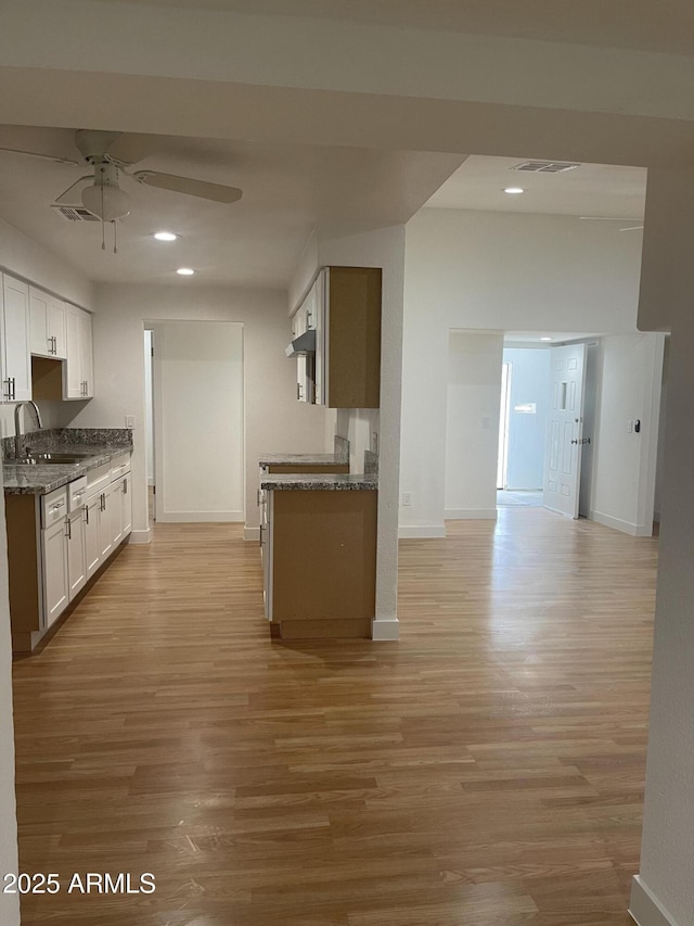 kitchen featuring white cabinets, sink, and light hardwood / wood-style flooring