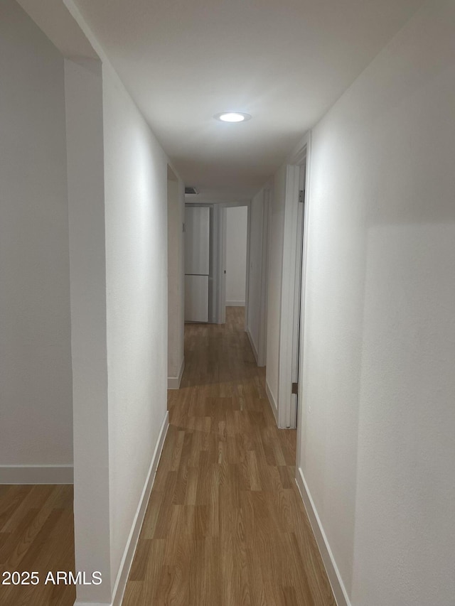 corridor with light hardwood / wood-style flooring