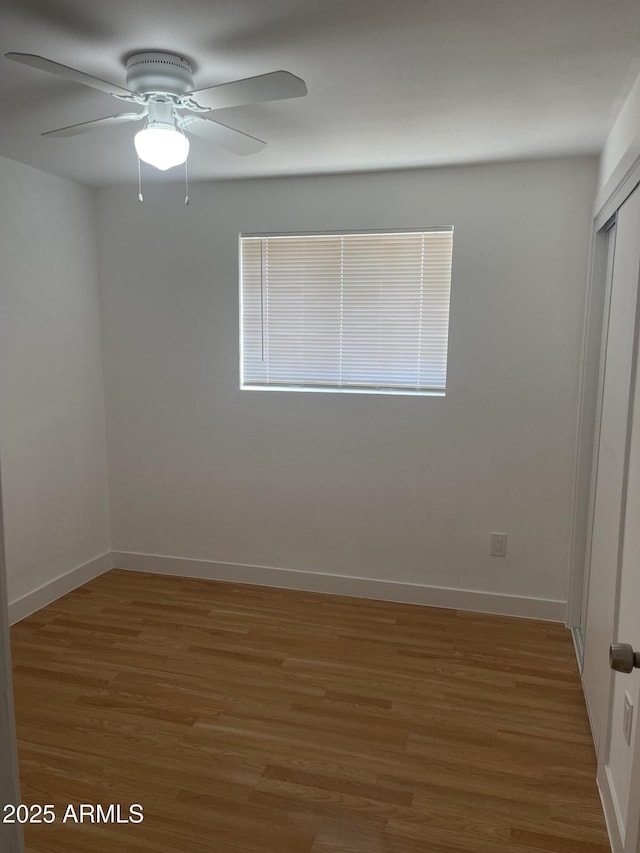 unfurnished bedroom with ceiling fan, dark wood-type flooring, and a closet