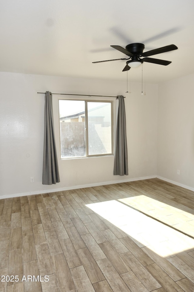 unfurnished room featuring light wood-type flooring and baseboards