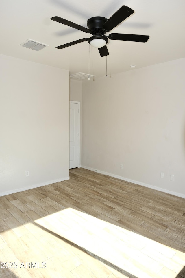 unfurnished room with light wood finished floors, baseboards, and visible vents