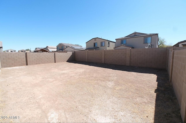 view of yard with a patio area, a fenced backyard, and a residential view