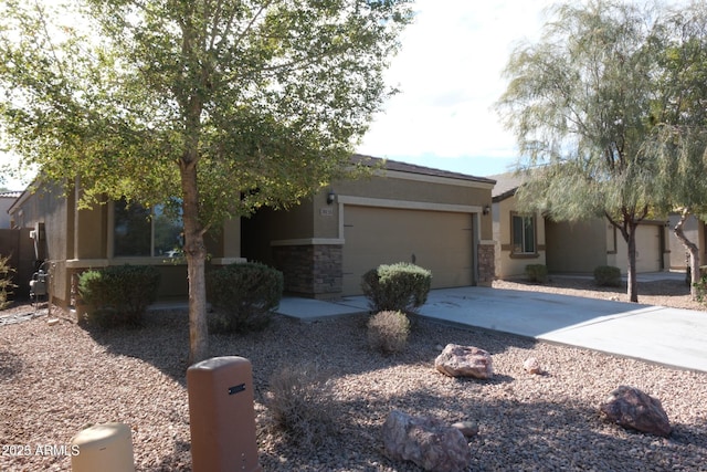 view of front of house featuring a garage, stone siding, concrete driveway, and stucco siding