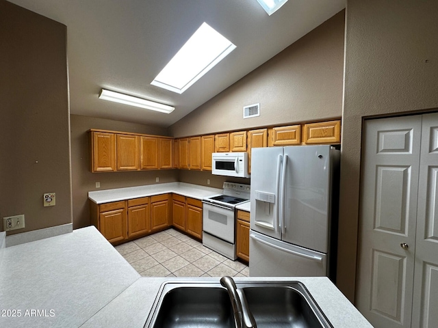 1836 N Stapley Dr Unit 88, Mesa, AZ 85203 - kitchen featuring white appliances, lofted ceiling, light countertops, a sink, and light tile patterned flooring