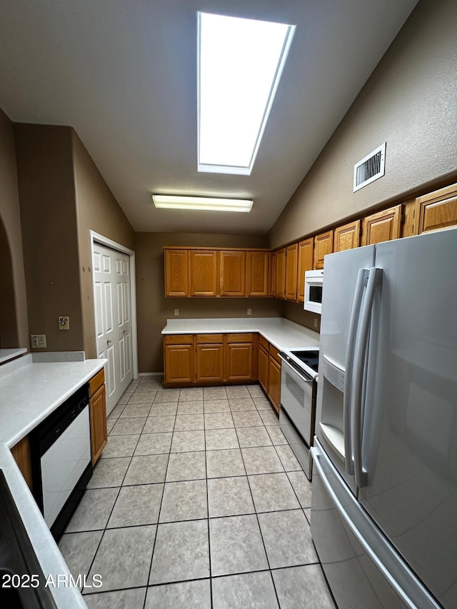 1836 N Stapley Dr Unit 88, Mesa, AZ 85203 - kitchen featuring white appliances, vaulted ceiling, light countertops, light tile patterned floors, and brown cabinets