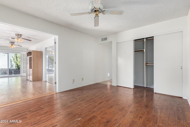 unfurnished bedroom featuring a textured ceiling, dark hardwood / wood-style floors, and ceiling fan