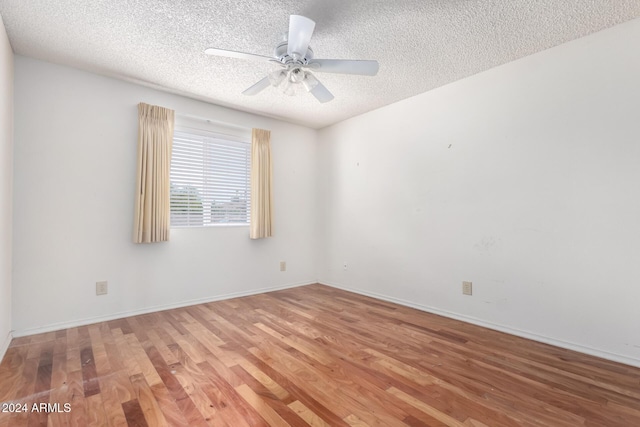 empty room featuring hardwood / wood-style flooring, ceiling fan, and a textured ceiling