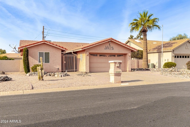 ranch-style house featuring cooling unit and a garage