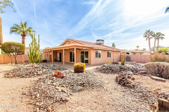 rear view of house with ceiling fan and a patio area