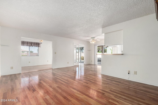 unfurnished living room with hardwood / wood-style flooring, ceiling fan, and a healthy amount of sunlight