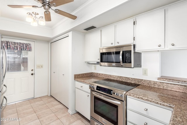 kitchen with appliances with stainless steel finishes, ceiling fan, crown molding, white cabinetry, and light tile patterned flooring