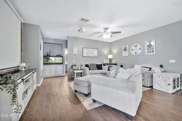 living room with ceiling fan and dark wood-type flooring