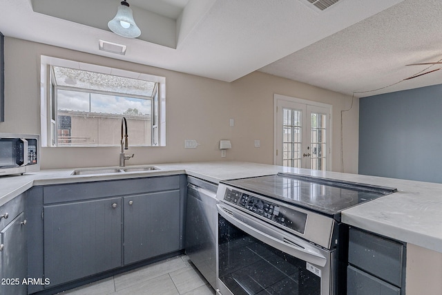 kitchen featuring gray cabinets, stainless steel appliances, and a sink