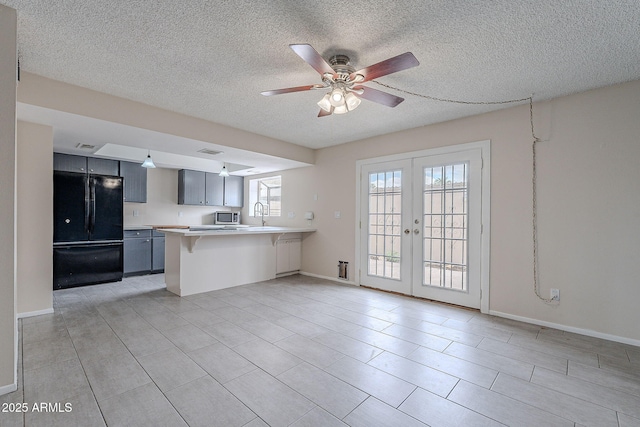 kitchen with a breakfast bar, light countertops, french doors, a peninsula, and freestanding refrigerator