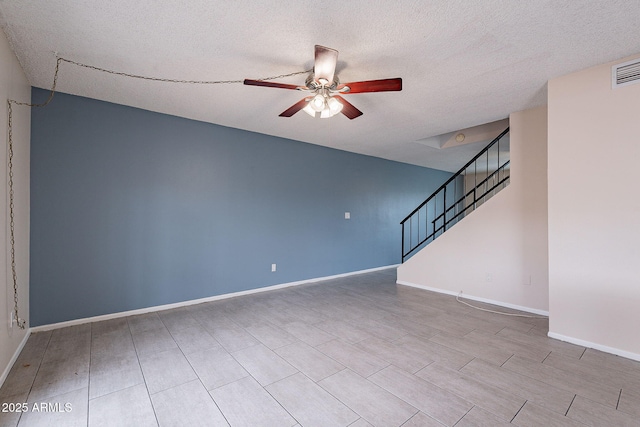 unfurnished living room with visible vents, a textured ceiling, baseboards, ceiling fan, and stairs