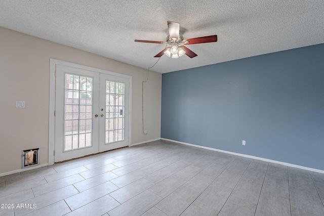 spare room with a textured ceiling, french doors, baseboards, and a ceiling fan