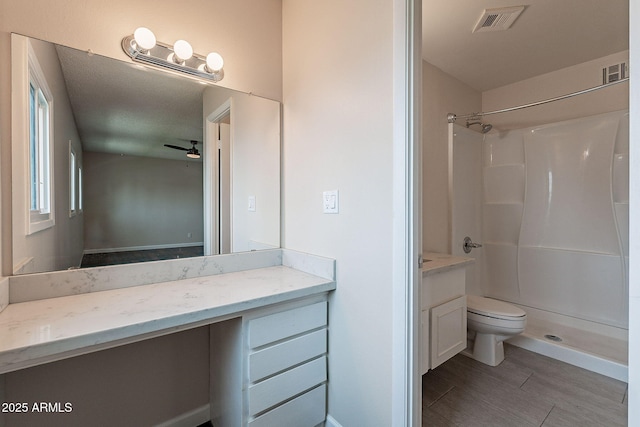 full bathroom featuring visible vents, toilet, a stall shower, and vanity