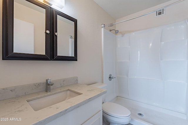 full bath featuring vanity, toilet, a shower, and visible vents