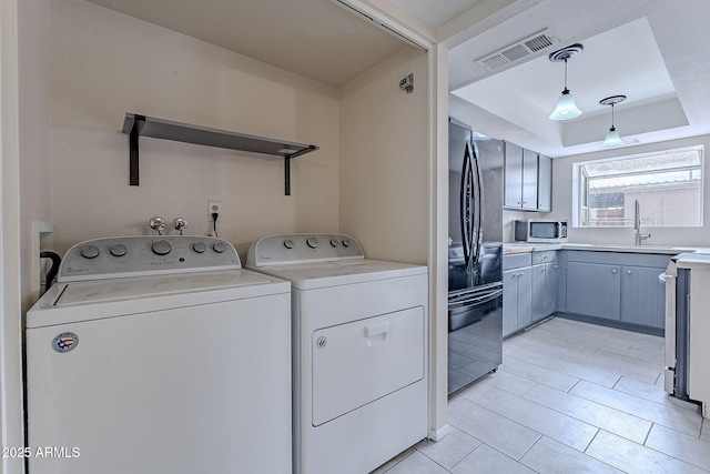 laundry area featuring laundry area, washing machine and dryer, and visible vents