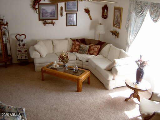 carpeted living room featuring ceiling fan