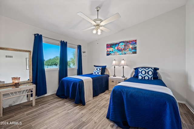 bedroom with ceiling fan, hardwood / wood-style floors, and lofted ceiling