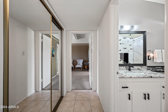 hallway with sink and light tile flooring