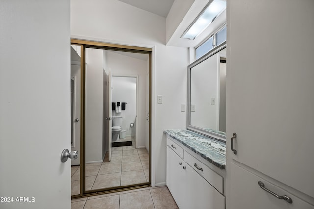 bathroom featuring toilet, tile floors, and vanity