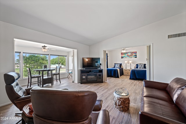 living room featuring wood-type flooring, vaulted ceiling, and ceiling fan