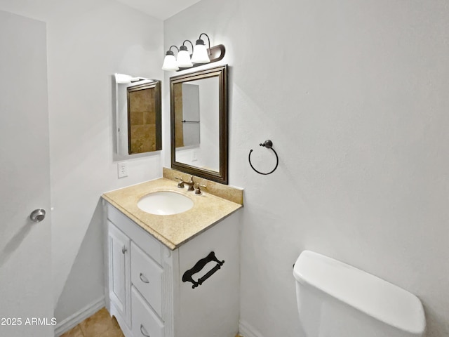 bathroom featuring baseboards, toilet, and vanity