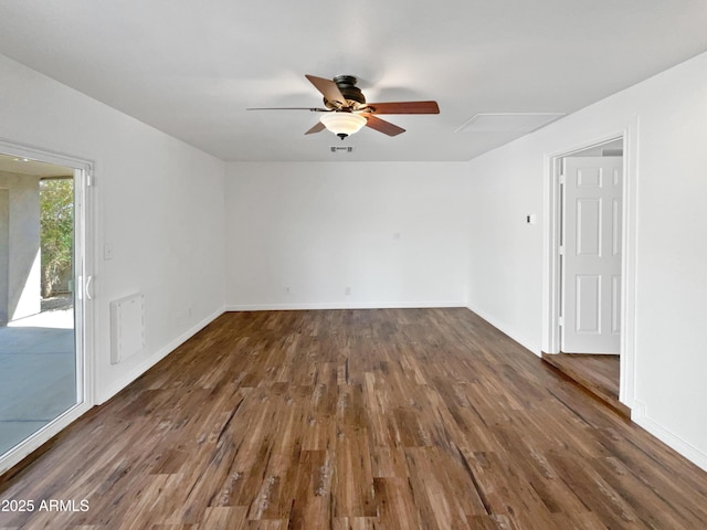 spare room featuring visible vents, baseboards, dark wood-type flooring, and a ceiling fan