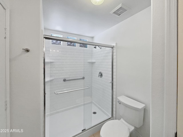 bathroom with visible vents, toilet, and a shower stall