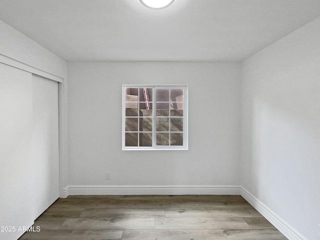 empty room featuring baseboards and wood finished floors