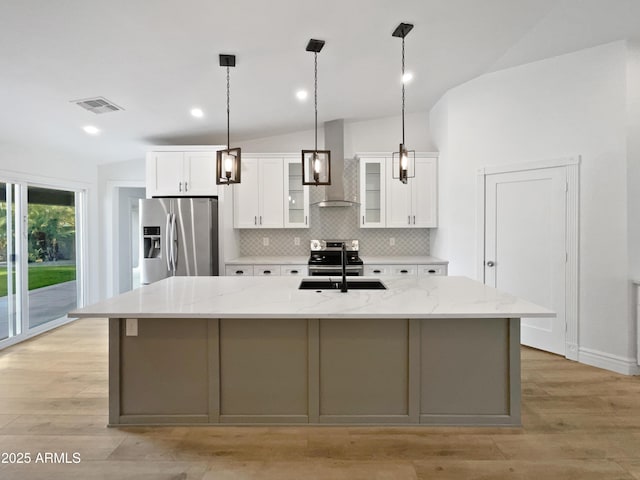 kitchen featuring visible vents, a large island, a sink, wall chimney exhaust hood, and stainless steel fridge with ice dispenser